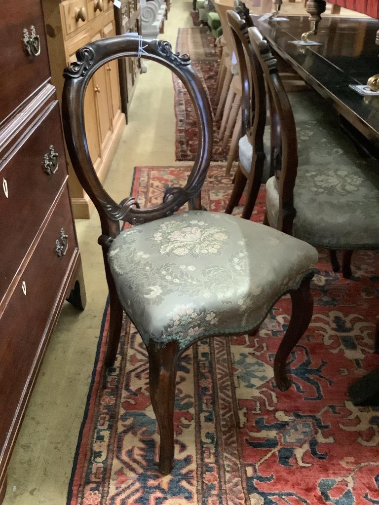 A set of four Victorian walnut balloon back dining chairs